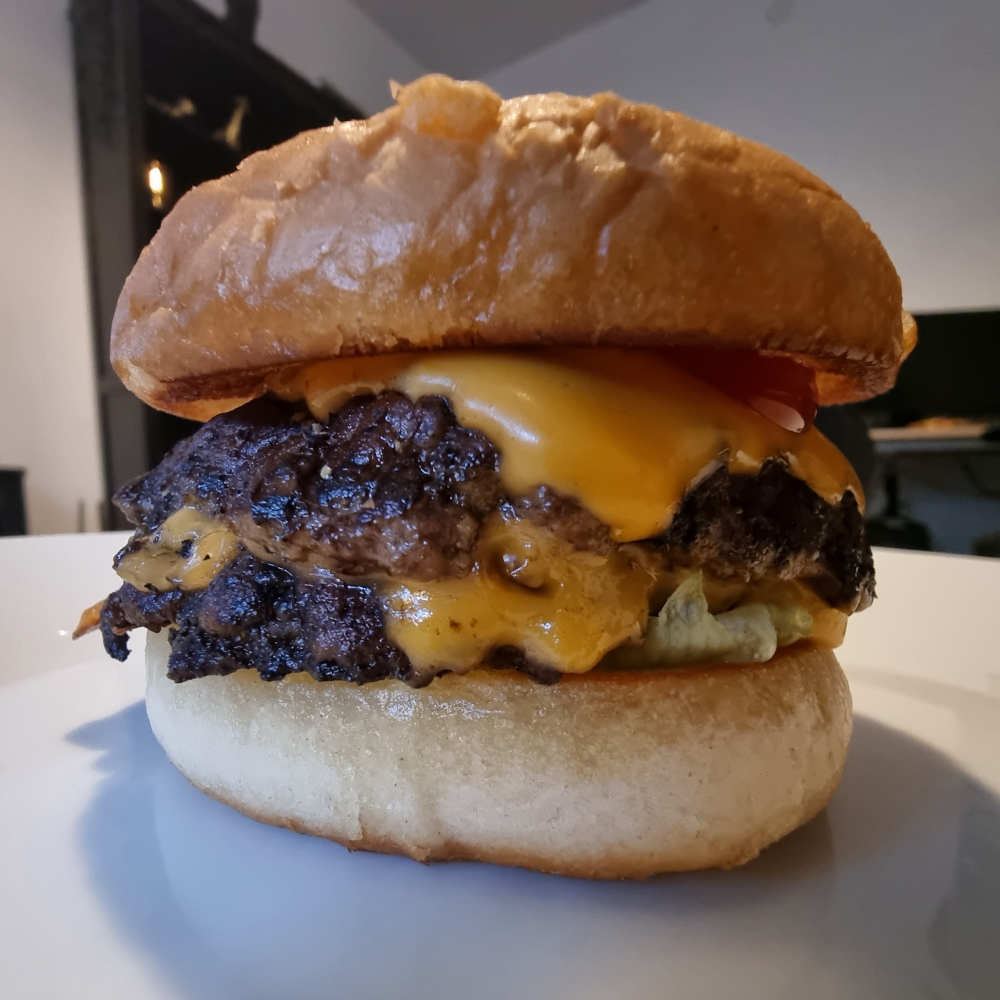 Hamburgare med bröd, ost, sallad och ketchup